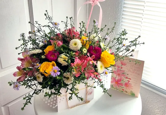 Colourful flower bag with yellow roses, pink alstroemeria and asters