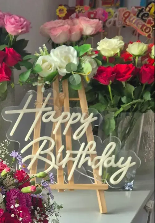 Happy Birthday neon sign on an easel with white and red roses, event styling in London
