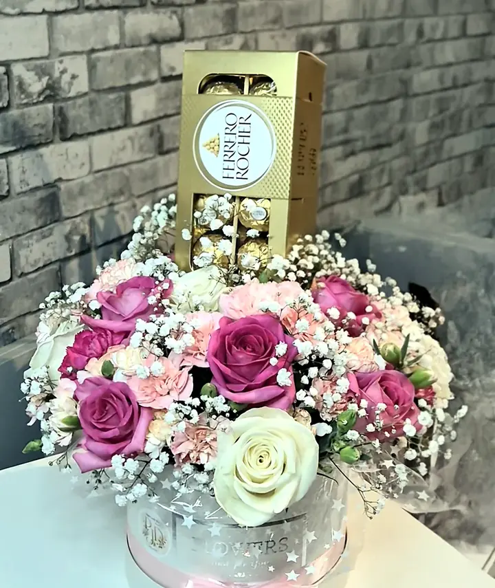 Pink roses and carnations in a flower hat box with Ferrero Rocher chocolates